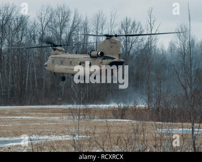 Eine CH-47 Chinook Bravo Company, 3.BATAILLON, 126 Aviation Regiment, New York Army National Guard aus Rochester, geflogen von Chief Warrant Officer 3 John hermanson und Chief Warrant Officer zwei Aaron Taylor zugewiesen, Piloten, um die 126 th zugeordnet, bereitet in einem simulierten taktischen Umfeld an der National Guard Training Website in Youngstown, N.Y., Jan. 12, 2019 zu landen. Die 126 ist die Infiltration und Exfiltration Unterstützung von Charlie Truppe, 2.Staffel, 101 Cavalry Regiment, NYARNG vom Büffel, während ihre kalte Wetter Übungen. (U.S. Air National Guard Foto von T Stockfoto