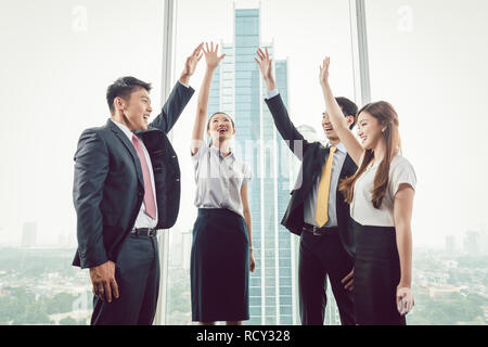 Gruppe von Geschäftsleuten heben ihre Hände Stockfoto