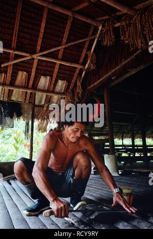 Muara Siberut, Mentawai Inseln/Indonesien - 15.August 2017: Stammes- Mitglied Aman schärfen seiner Machete an seinem Dschungel home Stockfoto