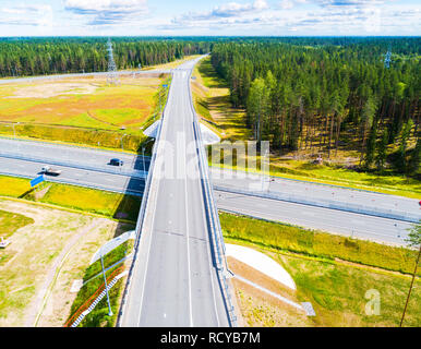 Luftaufnahme von der Autobahn in die Stadt. Autos Kreuzung interchange Überführung. Autobahn Interchange mit Verkehr. Aerial Vogelperspektive Foto von der Autobahn. Expressway. Stockfoto