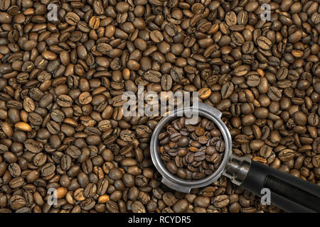 Kaffeebohnen in barista Löffel oder Schaufel mit Kaffeebohnen Hintergrund Stockfoto