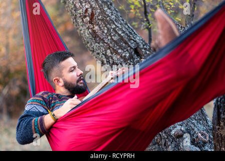 Mann in der Hängematte liegen und entspannen in der Natur Stockfoto