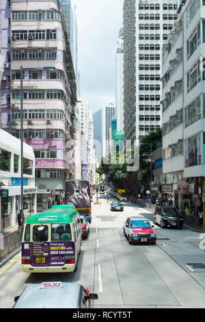 Gasse in Hongkong mit hohen Gebäuden auf beiden Seiten Stockfoto