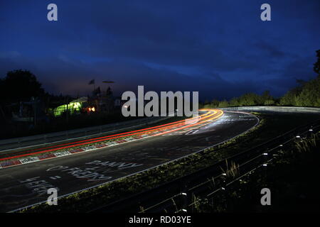 Rennwagen leuchten während des Nürburgring 24h-Rennen, langzeitbelichtung am Schwalbenschwanz Bend Stockfoto