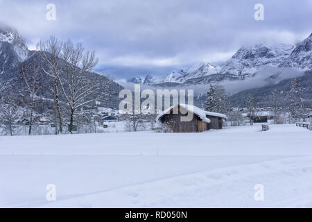 Winter Berglandschaft mit Holz im Vordergrund. Wetter und Nebel fallen in das Tal. Ehrwald, Österreich, Europa Stockfoto