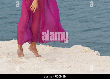 In der Nähe der Beine, eine Frau, die am Strand in einem langen Kleid Stockfoto