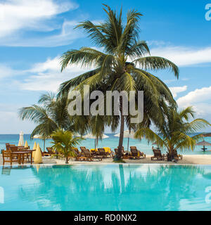 Blaues Wasser im Schwimmbad und flauschige Palmen. Luxury Resort auf tropischen iseland. Hotel Terrasse Stockfoto