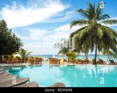 Blaues Wasser im Schwimmbad und flauschige Palmen. Luxury Resort auf tropischen iseland. Hotel Terrasse Stockfoto