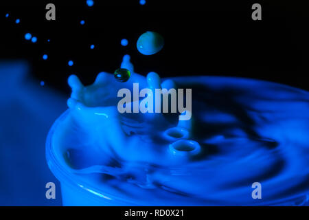 High speed Foto einer Karamell Milch drop auf dunklem Hintergrund im Studio Stockfoto