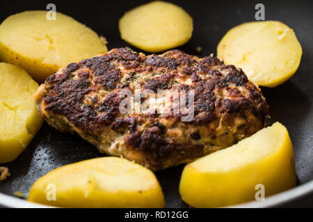 Hausgemachte Frikadelle Lachs mit Kartoffeln in der Pfanne. Organische Meeresfrüchte. Stockfoto