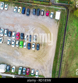 Vertikale Luftaufnahme eines Schotterparkplatz mit Reihen von geparkten Autos Stockfoto