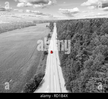 Luftaufnahme von Autobahn. Luftaufnahme von einer Landstraße mit beweglichen roten Auto. Auto vorbei. Antenne Straße. Luftbild fliegen. Von oben erfasst mit einem Stockfoto