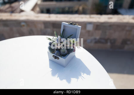 Zwei goldene Hochzeit Ringe in Schatulle mit frischen Blumen für die Zeremonie Stockfoto