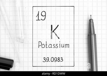 Das Periodensystem der Elemente. Handschrift chemische Element Kalium K mit schwarzem Stift, Reagenzglas und Pipette. Close-up. Stockfoto