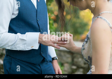 Braut mit einem Ring am Finger des Bräutigams Stockfoto