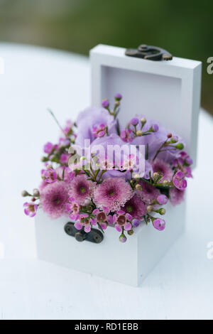 Sarg für Trauringe mit frischen Blumen für die Zeremonie Stockfoto