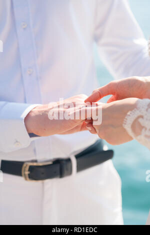 Braut mit einem Ring am Finger des Bräutigams Stockfoto