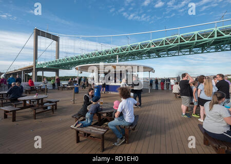 Touristen fotografieren, wenn die Fähre unter Älvsborgsbron, Göteborg, Schweden, February läuft. Stockfoto