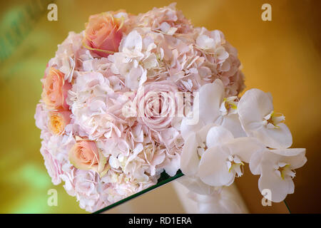 Klassische Blumenschmuck in einem Pastell pink hydrangea runde Blumenstrauß mit Rosen und Orchideen, auf einem edlen Glas Unterstützung als Mittelstück eingestellt Stockfoto