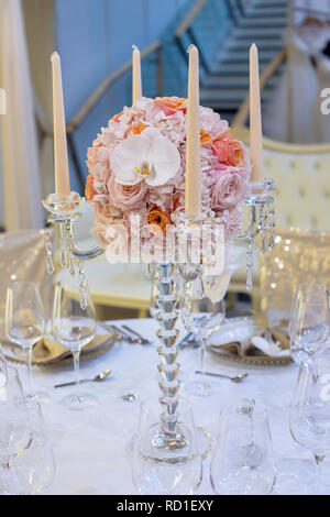 Schöne Kristallleuchter stil Kerzenhalter mit vier Scalloped bobeche und eine atemberaubende Runde Blumenstrauß in der Mitte eine Tabelle Mittelstück Stockfoto