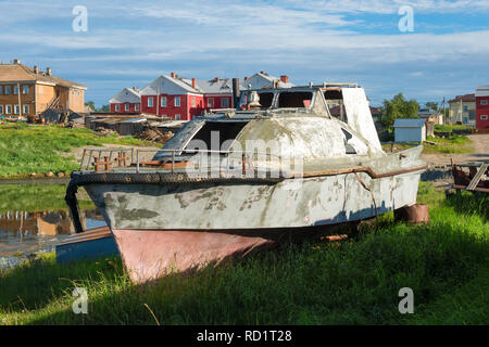 Altes Fischerboot an der Küste vor dem Hintergrund der Verklärung des Solovetsky Kloster. Solowki, Russland Stockfoto