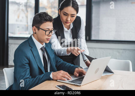 Junge kasachische Geschäftsleute mit Laptop im Büro Stockfoto