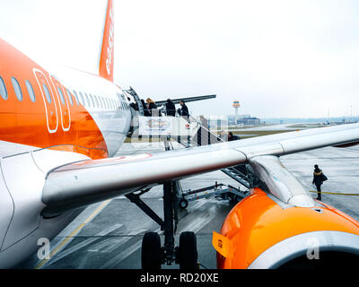 HAMBURG, DEUTSCHLAND - Mar 22, 2018: EasyJet Logo auf dem Flugzeug am frühen Morgen im Flughafen Hamburg durch die hintere Beifahrertür jetway Treppen Stockfoto