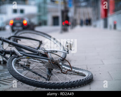 Eine alte gebrochen und verbogene Fahrrad mit verrosteten Kette in der Straße verworfen Stockfoto