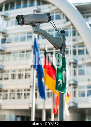 Eine Überwachungskamera auf einer Stange mit europäischen Flaggen im Hintergrund und Notfall Treffpunkt anmelden Stockfoto