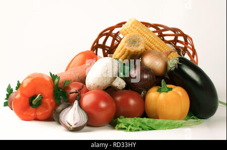 Pilze und eine Vielzahl von frischem Gemüse in einem Weidenkorb. Stockfoto