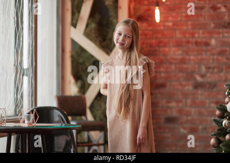 Lächelnde niedliche Mädchen in der Nähe des Tisches im Cafe Stockfoto