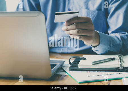 Unternehmer, die Kreditkarte und mit Laptop. Die Zahlung beim Online shopping. E-Commerce und moderne Technik Konzept Stockfoto
