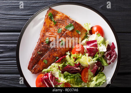 Gebratenes Zanderfilet mit frischem Salat in der Nähe serviert auf einem Teller. horizontal oben Ansicht von oben Stockfoto