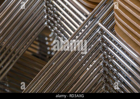 Gestapelte Stühle mit Holzsitzen und metallischen Beine Stockfoto