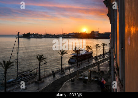 Die Sonne über dem Hafen Port als Boote Dock entlang der Uferpromenade in der Küstenstadt Brindisi, Italien, in der Region Apulien Stockfoto