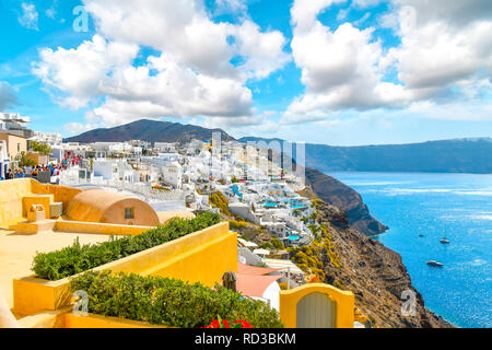 Einen malerischen Blick auf die Caldera von Santorin und die Ägäis von einem Resort Terrasse als Touristen zu Fuß die Hauptstraße in den Hang Dorf Oia Griechenland Stockfoto