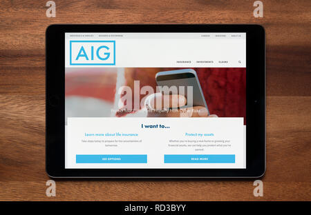 Die Website von AIG Insurance ist gesehen auf einem iPad Tablet, der ruht auf einem Holztisch (nur redaktionelle Nutzung). Stockfoto