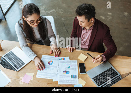Hohe Betrachtungswinkel der jungen Business Leute arbeiten mit Laptops und Papiere im Büro Stockfoto