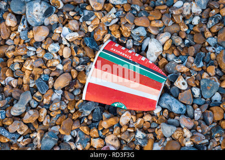 Wurf auf den Strand. Eine weggeworfene Starbucks Coffee Cup an einem Kieselstrand. Stockfoto