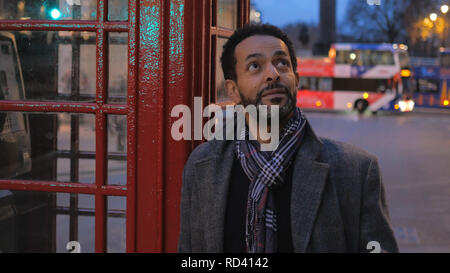 Mann in den Straßen von London - typische Ansicht mit Phone Booth Stockfoto