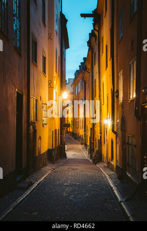 Klassische Dämmerung Blick auf traditionelle Häuser in der schönsten Gasse in der Stockholmer Altstadt Gamla Stan (Altstadt) während der Blauen Stunde in der Dämmerung leuchtet Stockfoto