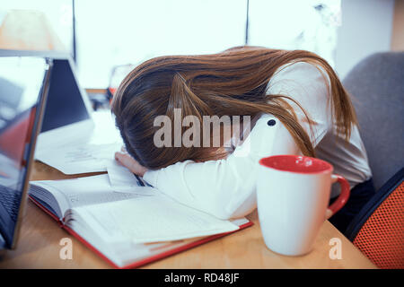 Die Mädchen schliefen am Arbeitsplatz Stockfoto