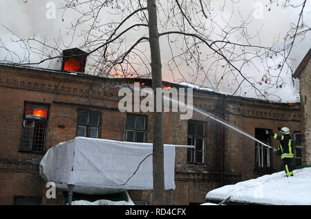 Kiew, Kiew, Ukraine. 16 Jan, 2019. Eine ukrainische Feuerwehrmann gesehen, die versuchen, ein Feuer in einem historischen Gebäude liegt nicht weit von dem Platz der Unabhängigkeit, in der Innenstadt von Kiew zu löschen. Über das 16 Feuerwehr- Einheiten und 62 Feuerwehrleute Personal waren erforderlich, um das Feuer zu kontrollieren. Kein Körper starben oder verletzt wurden, während ein Brand in einem der historischen Gebäude im Hof des Dnipro Hotel im Zentrum von Kiew. Credit: Pavlo Gontschar/SOPA Images/ZUMA Draht/Alamy leben Nachrichten Stockfoto