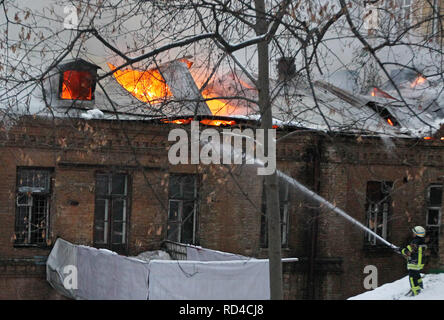 Kiew, Kiew, Ukraine. 16 Jan, 2019. Eine ukrainische Feuerwehrmann gesehen, die versuchen, ein Feuer in einem historischen Gebäude liegt nicht weit von dem Platz der Unabhängigkeit, in der Innenstadt von Kiew zu löschen. Über das 16 Feuerwehr- Einheiten und 62 Feuerwehrleute Personal waren erforderlich, um das Feuer zu kontrollieren. Kein Körper starben oder verletzt wurden, während ein Brand in einem der historischen Gebäude im Hof des Dnipro Hotel im Zentrum von Kiew. Credit: Pavlo Gontschar/SOPA Images/ZUMA Draht/Alamy leben Nachrichten Stockfoto