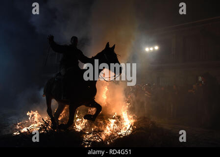 Januar 16, 2019 - San Bartolome de Pinares, Vila, Spanien - ein Mann reitet auf einem Pferd durch ein Lagerfeuer als Teil eines Rituals zu Ehren des heiligen Antonius, dem Schutzpatron der Haustiere, in San Bartolome de Pinares, Spanien. Quelle: John milner/SOPA Images/ZUMA Draht/Alamy leben Nachrichten Stockfoto