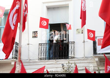 Tunis, Tunesien. 17 Jan, 2019. Noureddine Taboubi, Generalsekretär der Tunesischen allgemeine Gewerkschaft, wirft die Blumen an Demonstranten vom Balkon der Hauptsitz der Union während eines Protestes als Teil eines Generalstreiks. Der landesweite Streik ist das neueste in einer Reihe von Protesten nach dem Scheitern der Verhandlungen mit der Regierung über Lohnerhöhungen. Credit: Khaled Nasraoui/dpa/Alamy leben Nachrichten Stockfoto