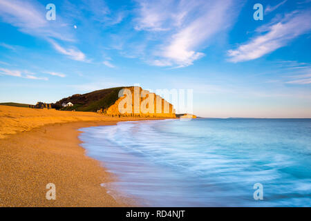 West Bay, Dorset, Großbritannien. 17. Januar 2019. UK Wetter. Der Sandstein Klippen am West Bay in Dorset glow Orange am späten Nachmittag Sonnenschein kurz vor Sonnenuntergang nach einem Tag mit kühlen Temperaturen und Sonnenschein mit blauem Himmel. Hohe Cloud ist Anfang der Himmel als eine aus dem Westen Ansätze zu füllen. Foto: Graham Jagd-/Alamy leben Nachrichten Stockfoto