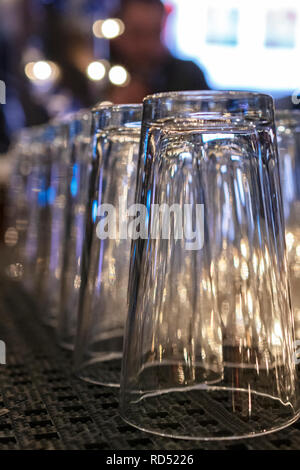 Auf der Suche einer Reihe von Biergläsern in einer Taverne. Verschwommen Patron im Hintergrund. Stockfoto