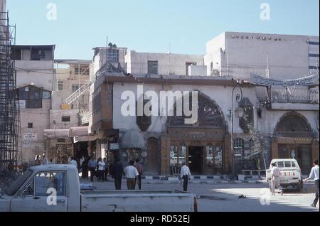 Viel befahrenen Straße Szene nahe dem Eingang der Omayyaden-moschee, in der Altstadt von Damaskus, Syrien, Juni, 1994. Unten links ist ein Zeichen Regie Besucher der Umayyaden Palace Restaurant. () Stockfoto