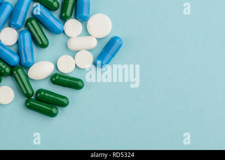 Verschüttete Pillen über Hellblau Stockfoto